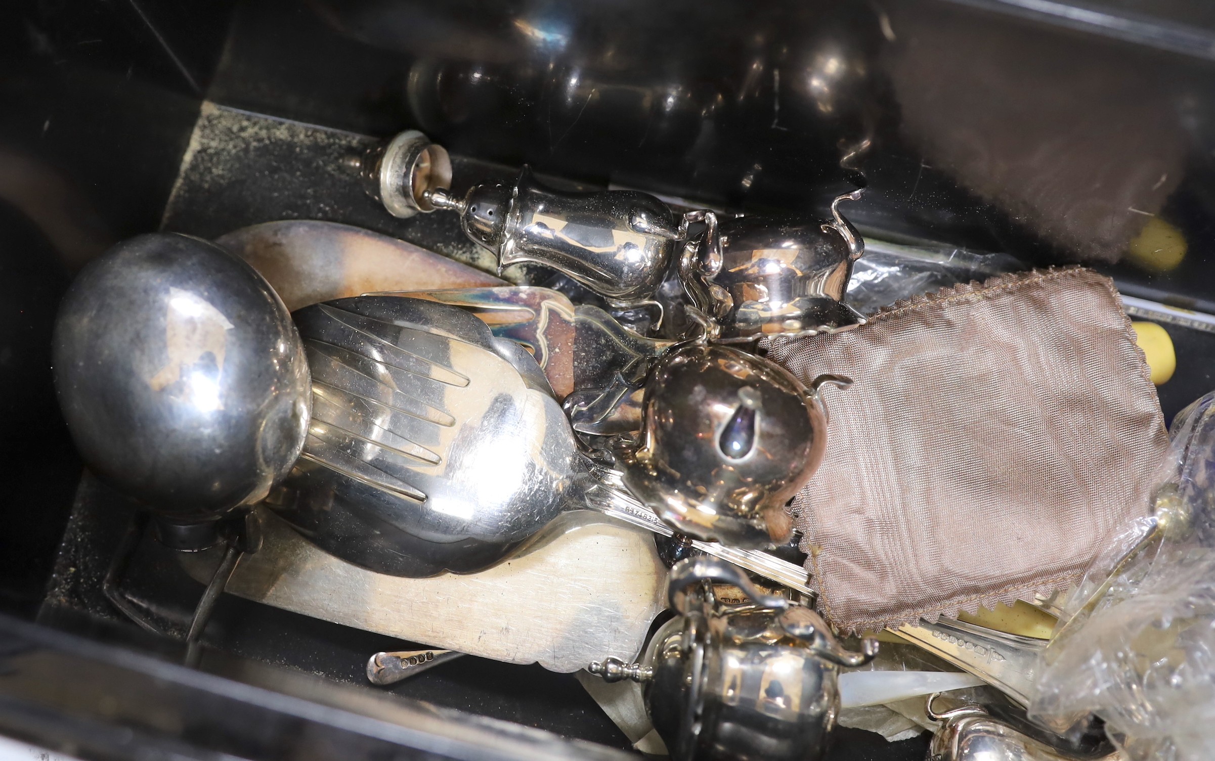 A tin box containing silver plated cutlery and cruets etc